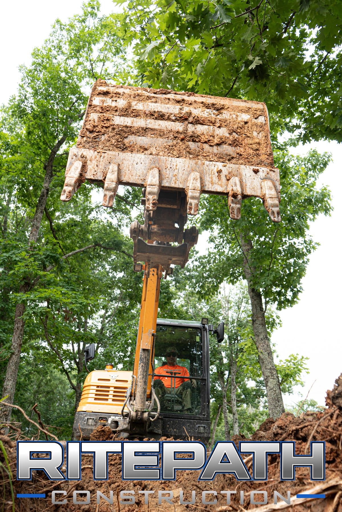 Excavator clearing land